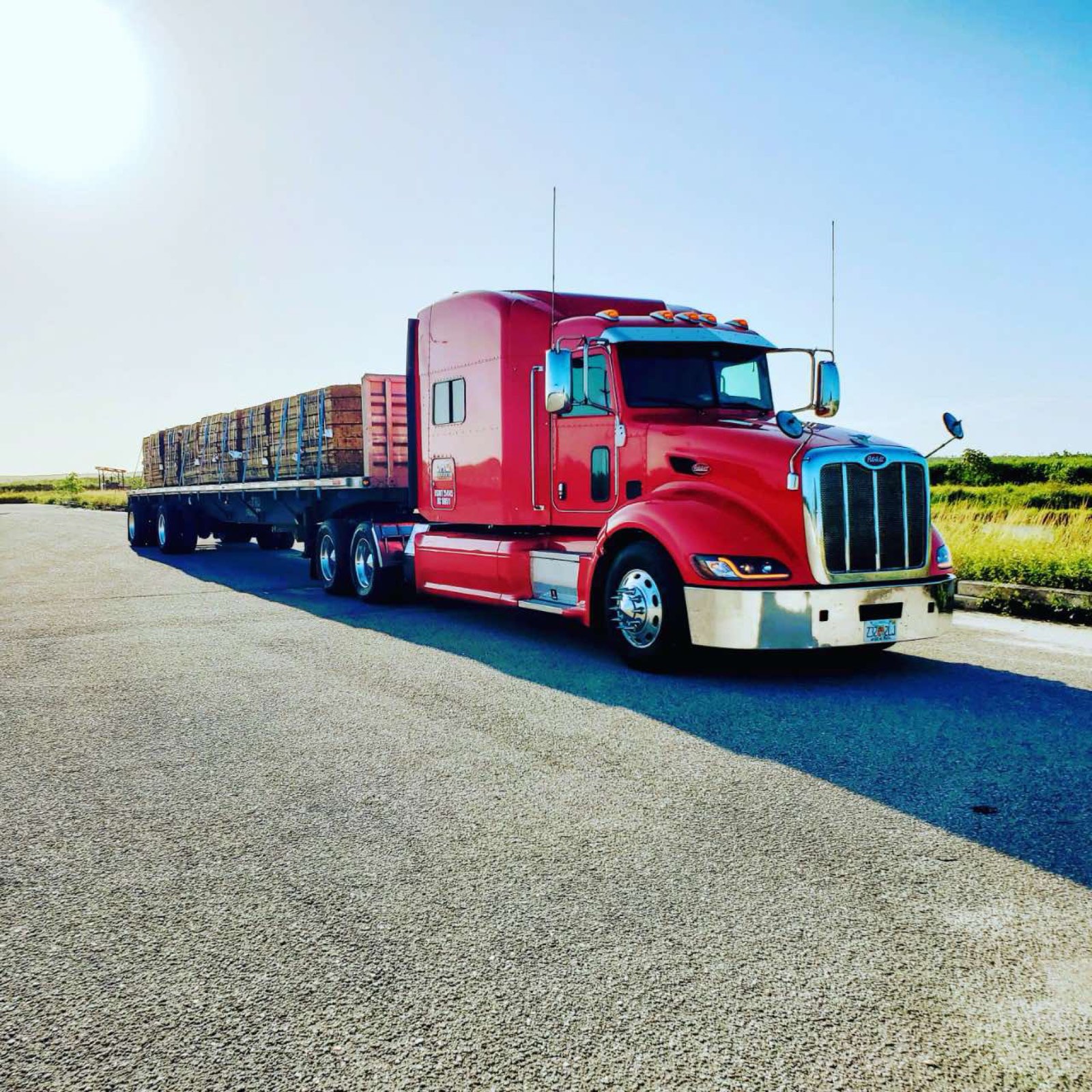 Peterbilt flatbed hauling a loaded trailer
